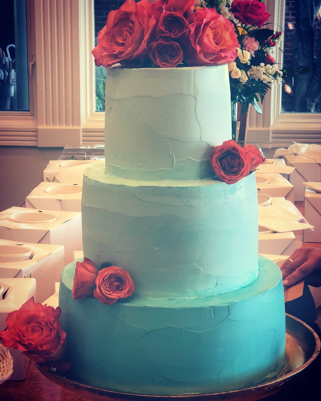 3 tier blue ombre wedding cake covered in roses