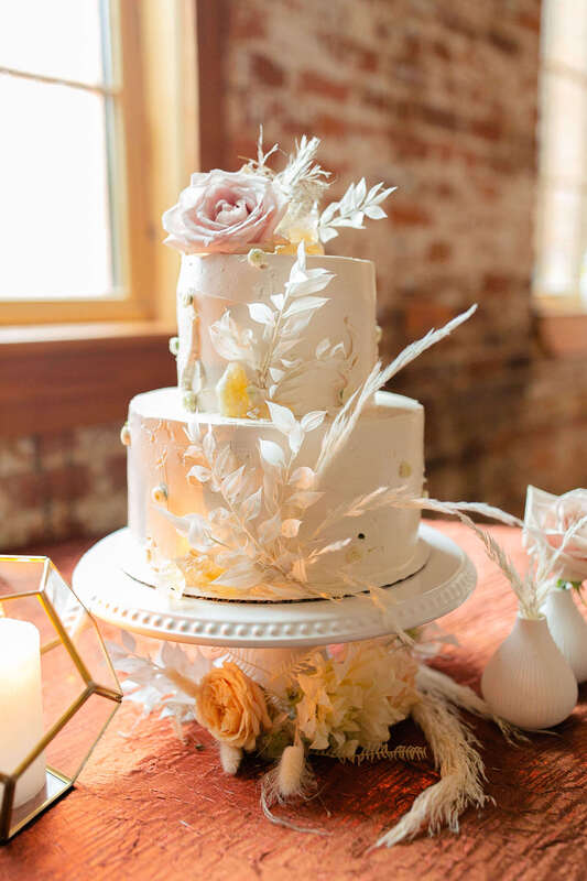Bohemian wedding cake covered in feathers and flowers