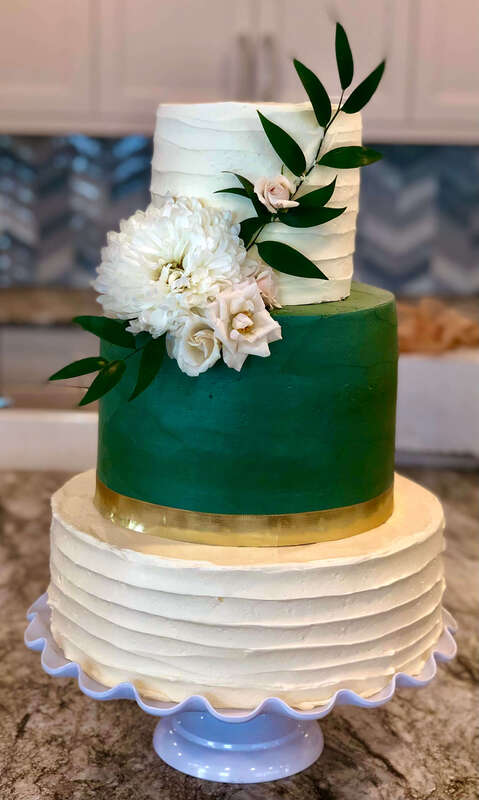 3 tier wedding cake with dark green layer and flowers