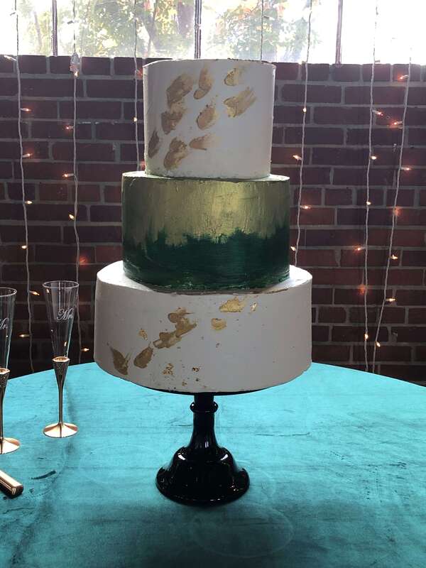 3 tier wedding cake with dark green and gold leaf