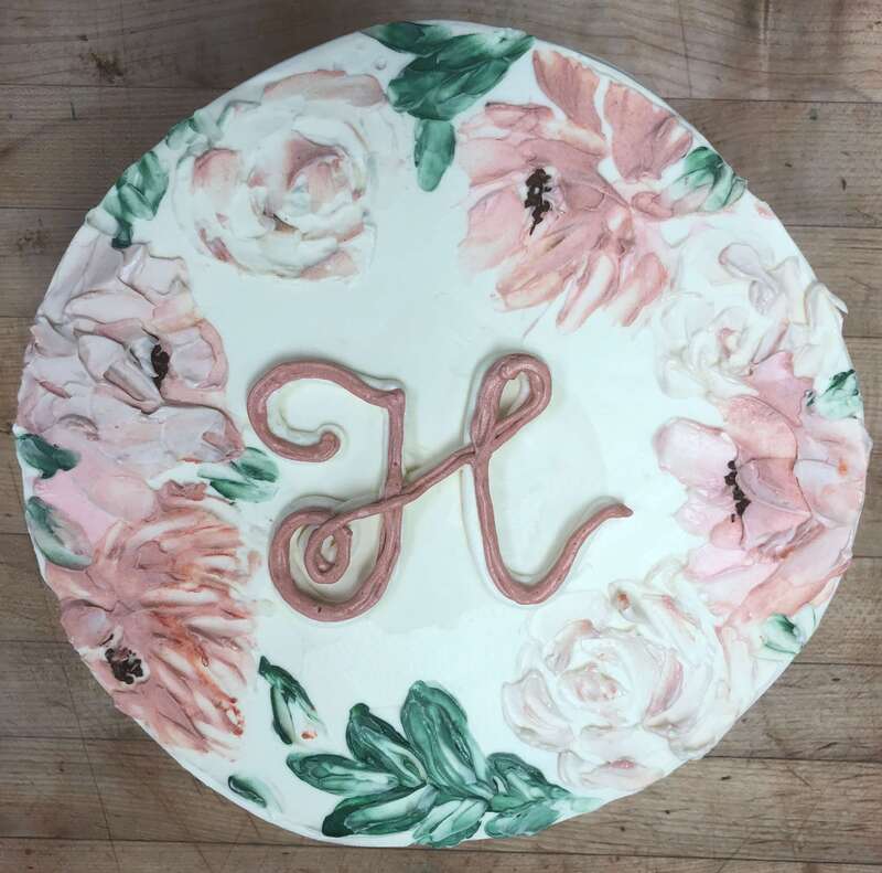 bridal shower cake covered in buttercream flowers and a monogram H