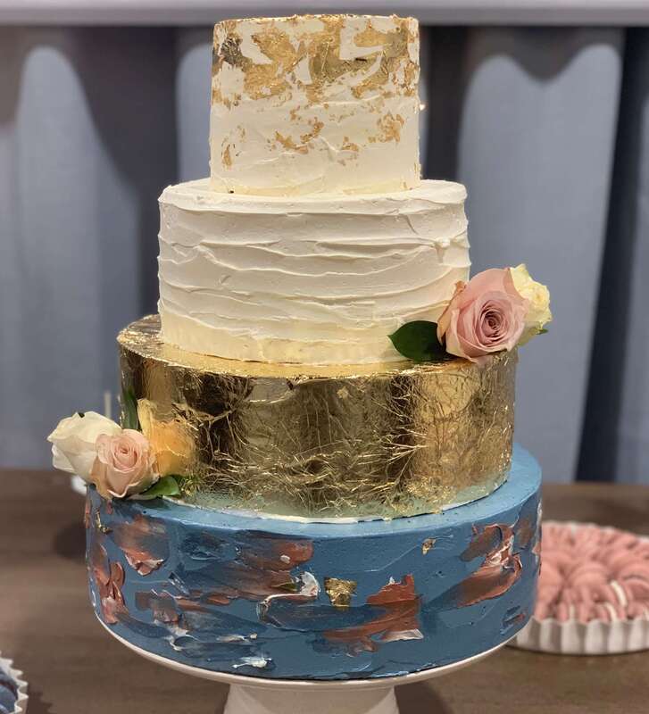 Unique, 4-tier wedding cake with gold leaf and handpainted buttercream icing